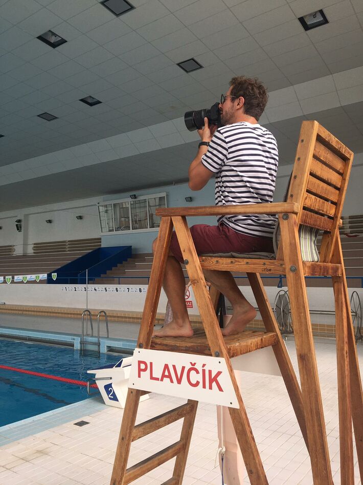 Marek Jančúch pri fotografovaní mozaiky na plavárni.